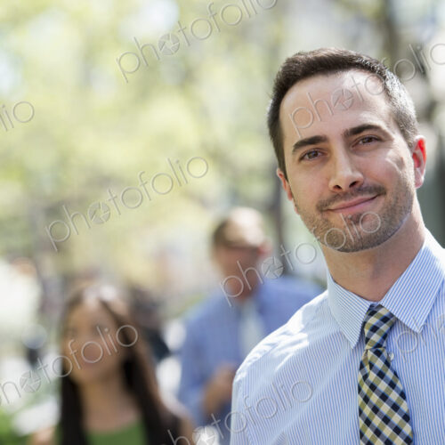A small group of people, a businesswoman and two businessmen outdoors in the city. A small group of people, a businesswoman and two businessmen outdoors in the city.