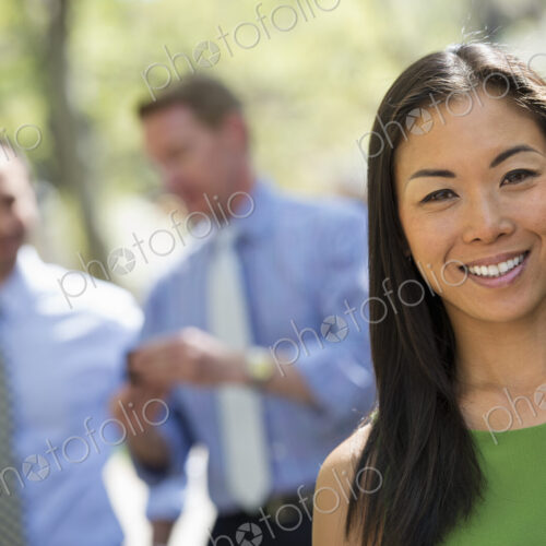 A small group of people, a businesswoman and two businessmen outdoors in the city. A small group of people, a businesswoman and two businessmen outdoors in the city.