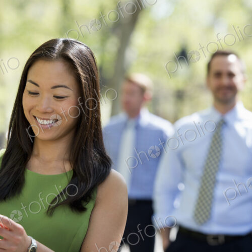 A small group of people, a businesswoman and two businessmen outdoors in the city. A small group of people, a businesswoman and two businessmen outdoors in the city.