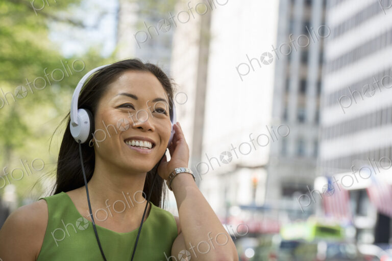 A small group of people, a businesswoman and two businessmen outdoors in the city.