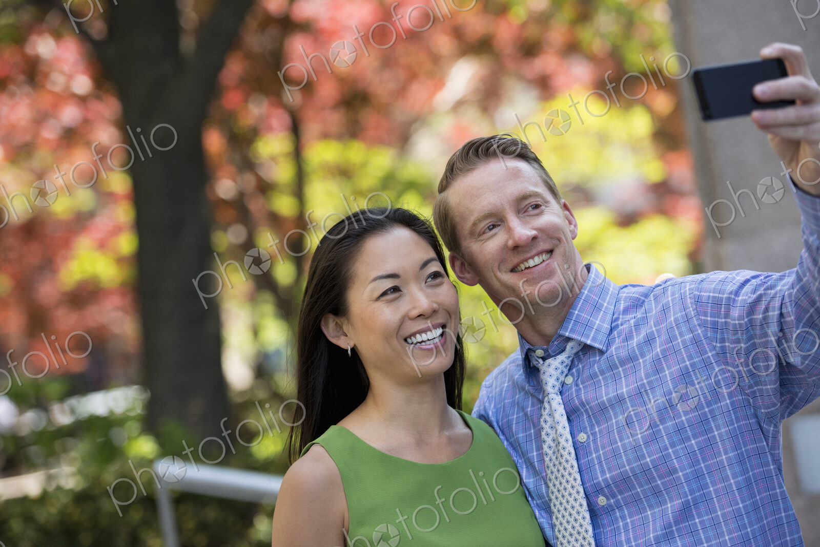 A small group of people, a businesswoman and two businessmen outdoors in the city.