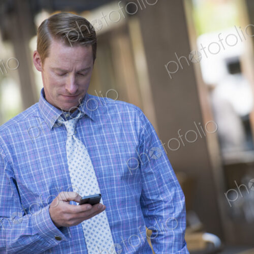A small group of people, a businesswoman and two businessmen outdoors in the city. A small group of people, a businesswoman and two businessmen outdoors in the city.