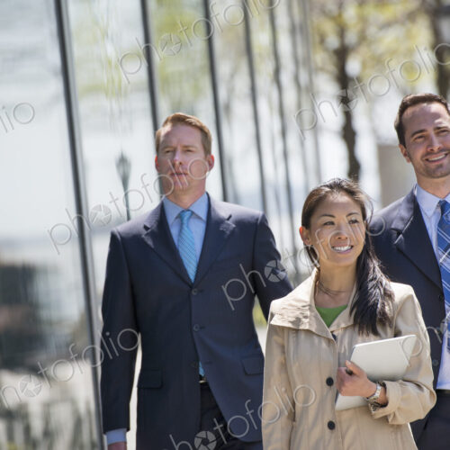 A small group of people, a businesswoman and two businessmen outdoors in the city. A small group of people, a businesswoman and two businessmen outdoors in the city.