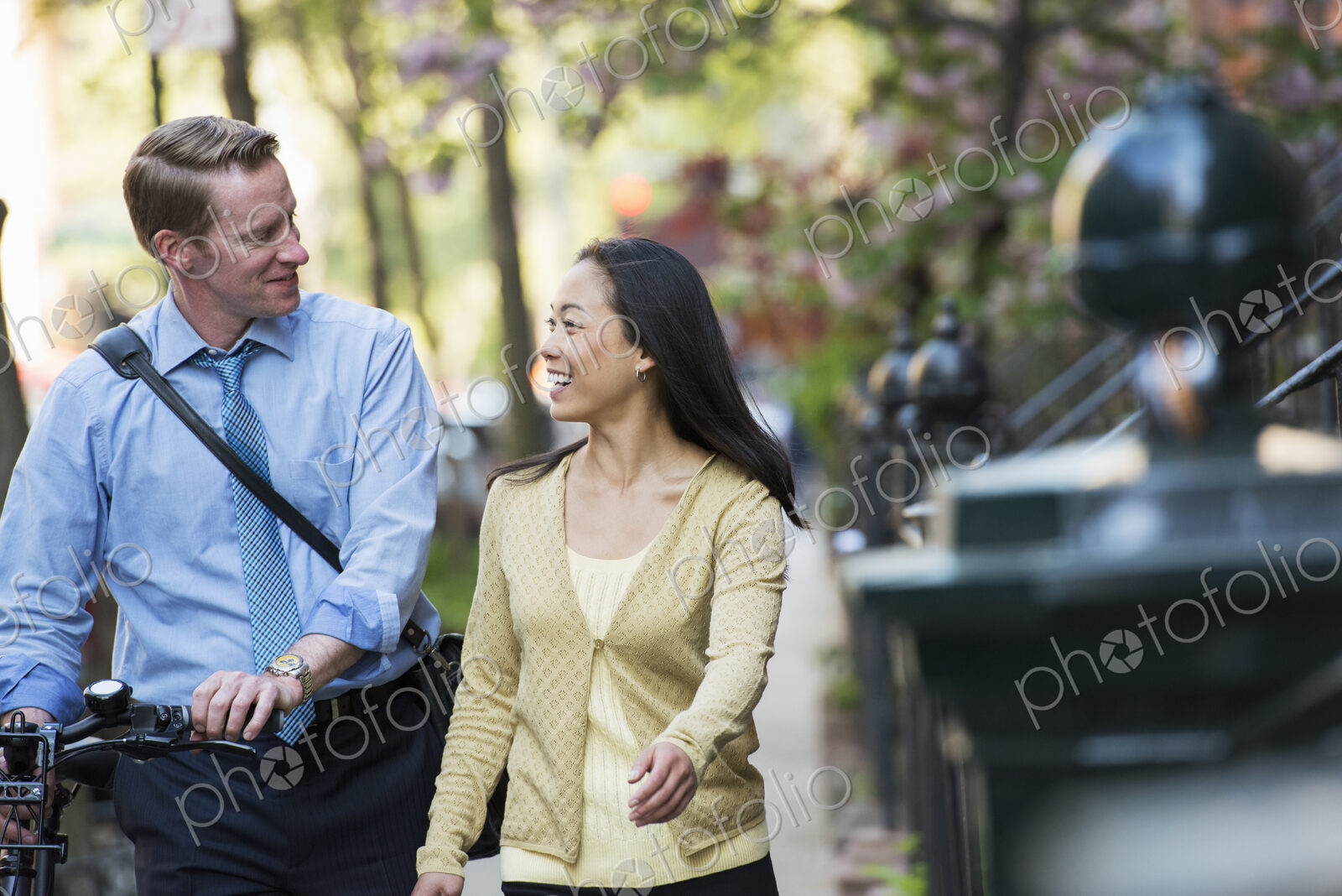 A small group of people, a businesswoman and two businessmen outdoors in the city.