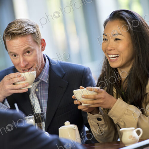 A small group of people, a businesswoman and two businessmen sitting in a coffee shop… A small group of people, a businesswoman and two businessmen sitting in a coffee shop…
