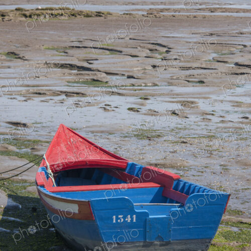 A small painted wooden fishing boat beached on the shores of Sado Estuary outside… A small painted wooden fishing boat beached on the shores of Sado Estuary outside…