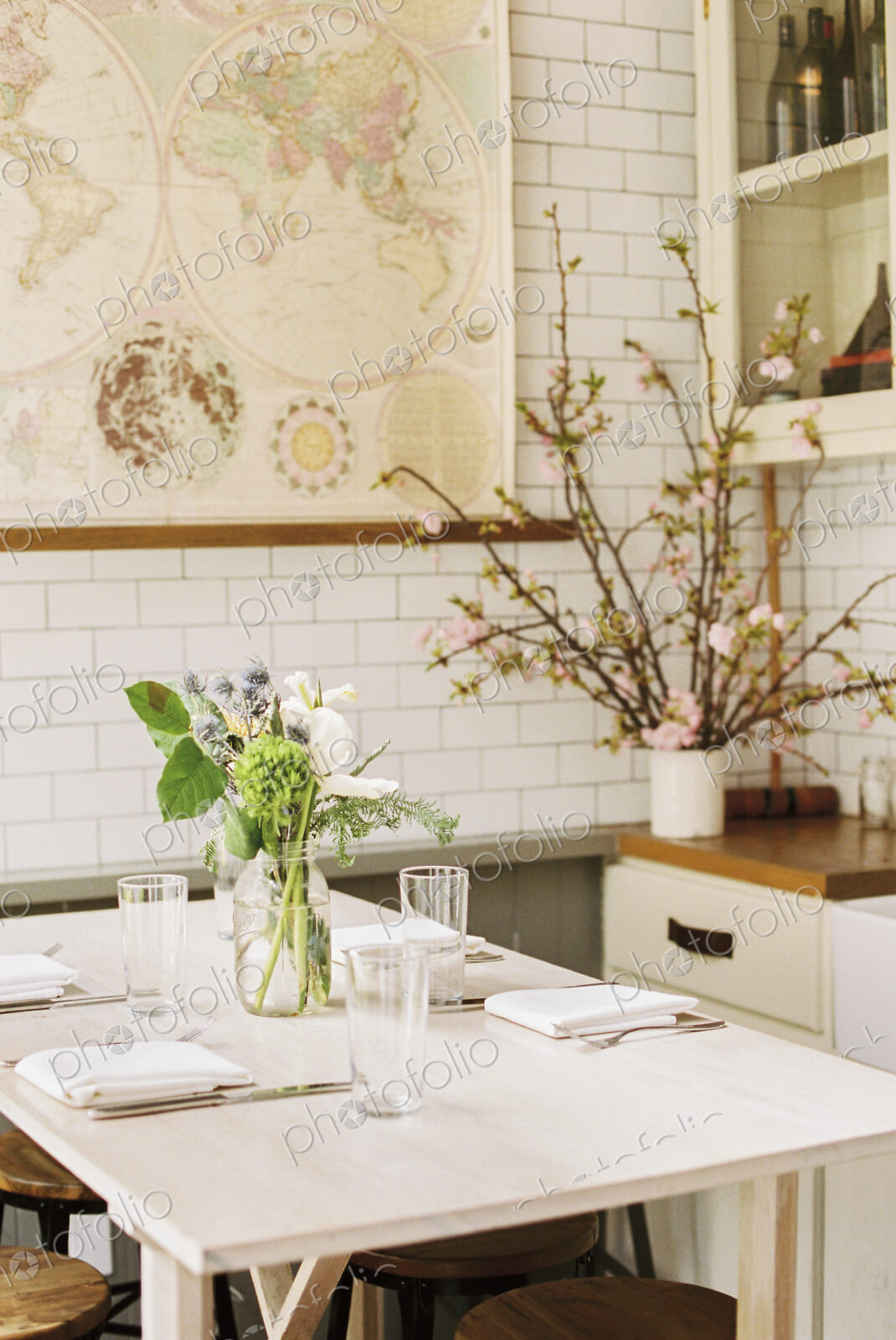 A small table with four place settings and flowers in a jar.