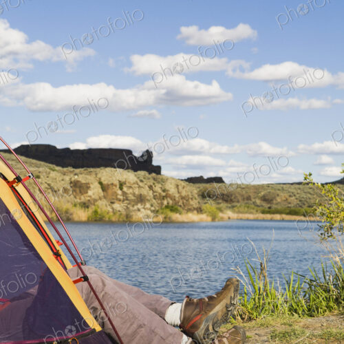 A small tent pitched by the shores of the Sun Lakes in Sun Lakes State Park. A man's…
