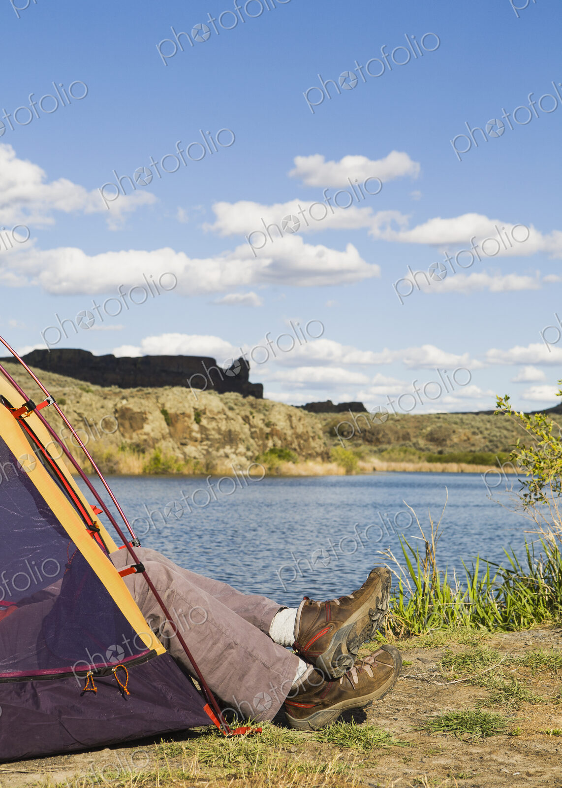 A small tent pitched by the shores of the Sun Lakes in Sun Lakes State Park. A man’s…