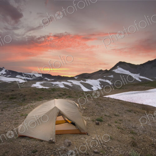 A small tent pitched on a screen slope just below the snowline, at sunset in the Mount… A small tent pitched on a screen slope just below the snowline, at sunset in the Mount…