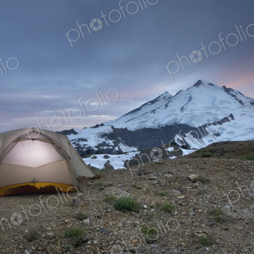 A small tent pitched on a screen slope just below the snowline, at sunset in the Mount… A small tent pitched on a screen slope just below the snowline, at sunset in the Mount…