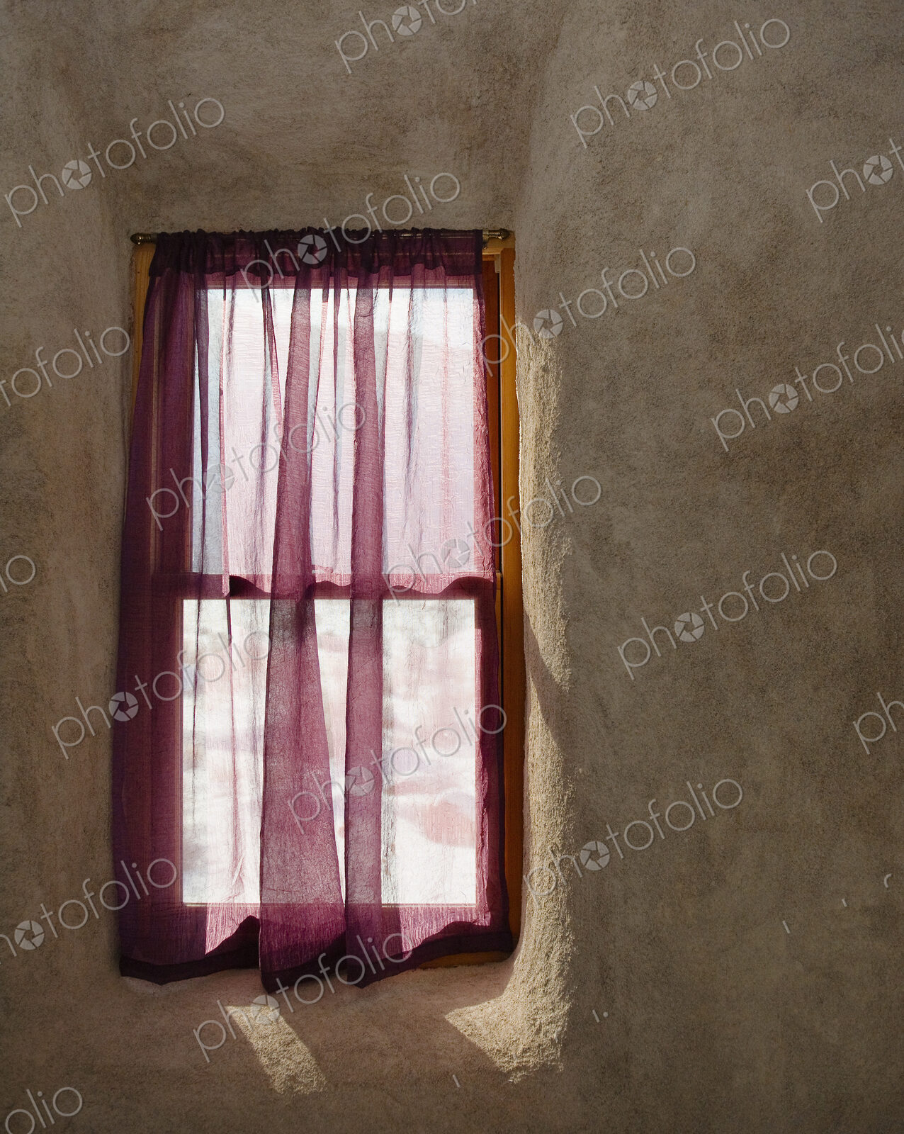 A small window in a wall, wooden frame, net curtain