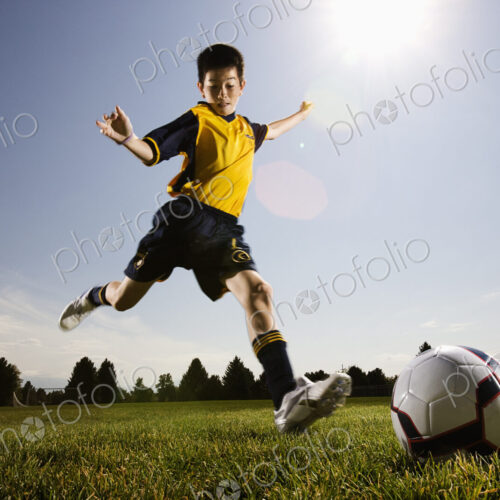 A soccer player, a boy preparing to kick a soccer ball. A soccer player, a boy preparing to kick a soccer ball.