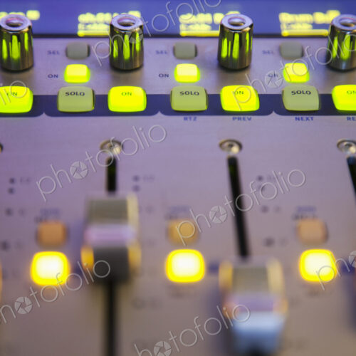 A sound board with lighted controls in a home recording studio A sound board with lighted controls in a home recording studio