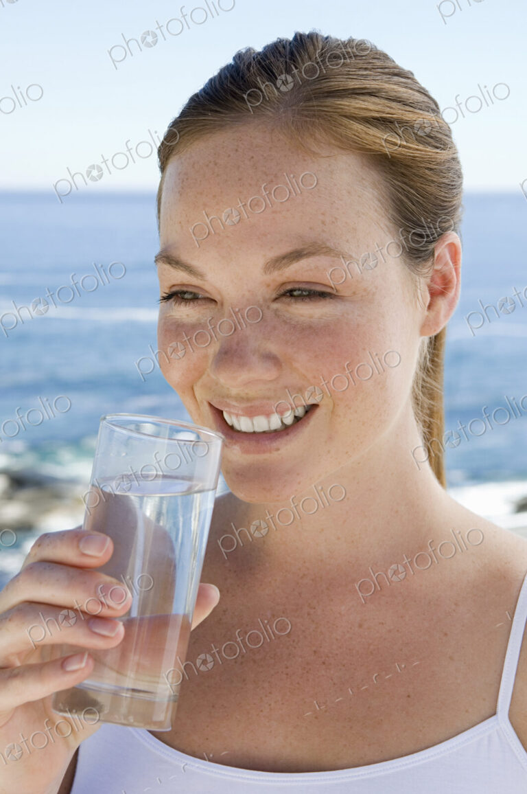 A spa treatment centre. A young woman drinking a glass of water.