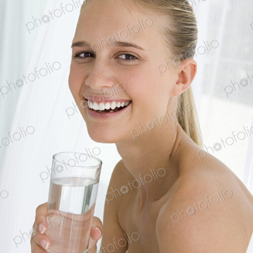 A spa treatment centre. A young woman drinking a glass of water. A spa treatment centre. A young woman drinking a glass of water.