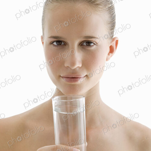 A spa treatment centre. A young woman drinking a glass of water for hydration. A spa treatment centre. A young woman drinking a glass of water for hydration.