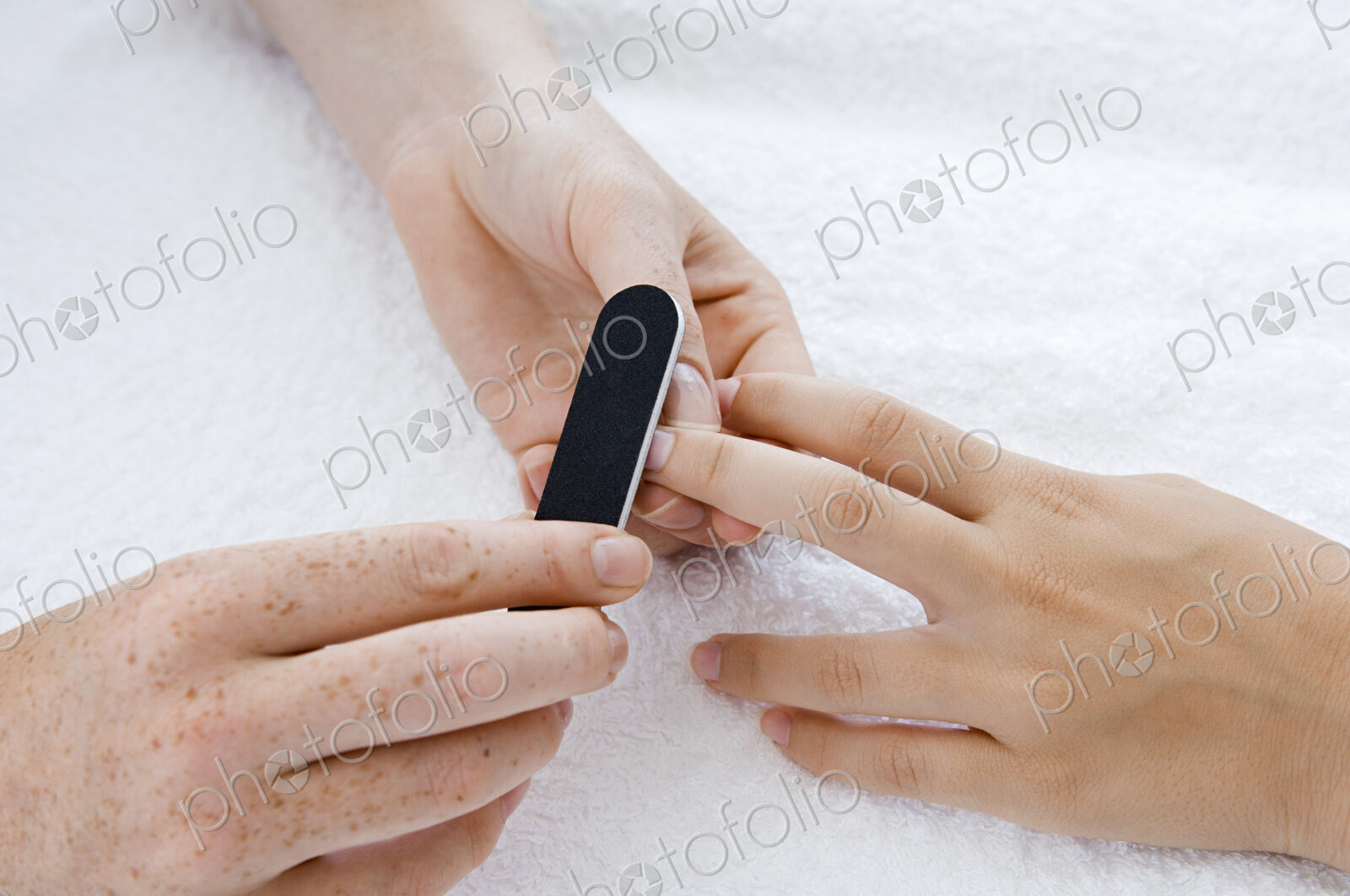 A spa treatment centre. A young woman having a manicure.