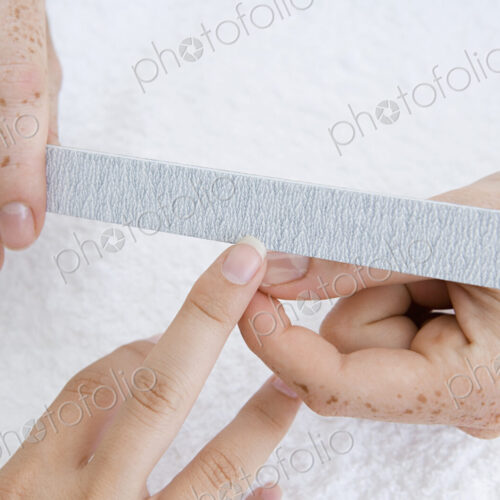 A spa treatment centre. A young woman having a manicure, having her fingernail filed. A spa treatment centre. A young woman having a manicure, having her fingernail filed.