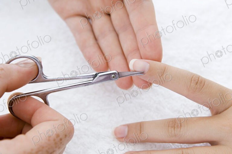 A spa treatment centre. A young woman having a manicure, having her fingernails shaped.