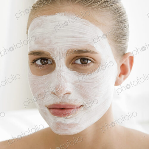 A spa treatment centre. A young woman with a white facial mask on her skin. A spa treatment centre. A young woman with a white facial mask on her skin.