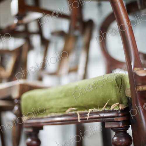 A stack of antique chairs, with fraying seas for refurbishment. A stack of antique chairs, with fraying seas for refurbishment.
