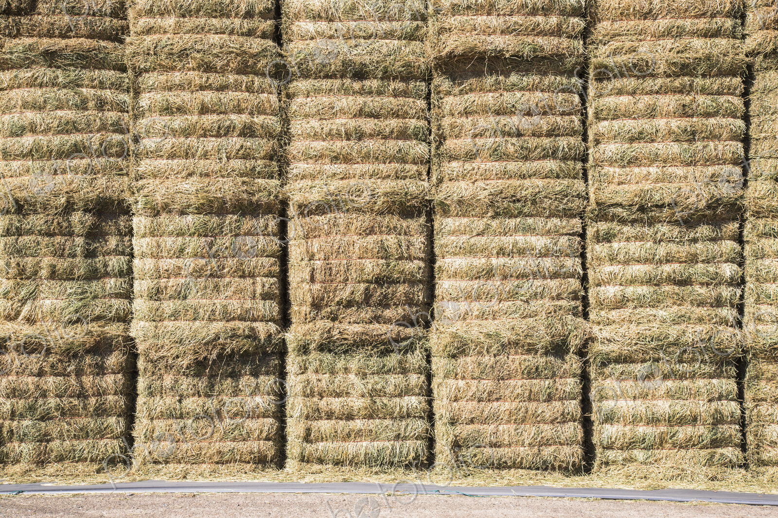 A stack of hay bales, stored in layers, to protect and keep the fodder material dry.