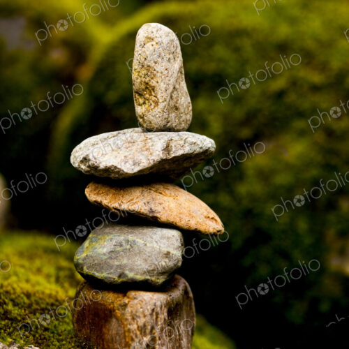 A stack of small rocks balanced on top of each other by a river. A stack of small rocks balanced on top of each other by a river.