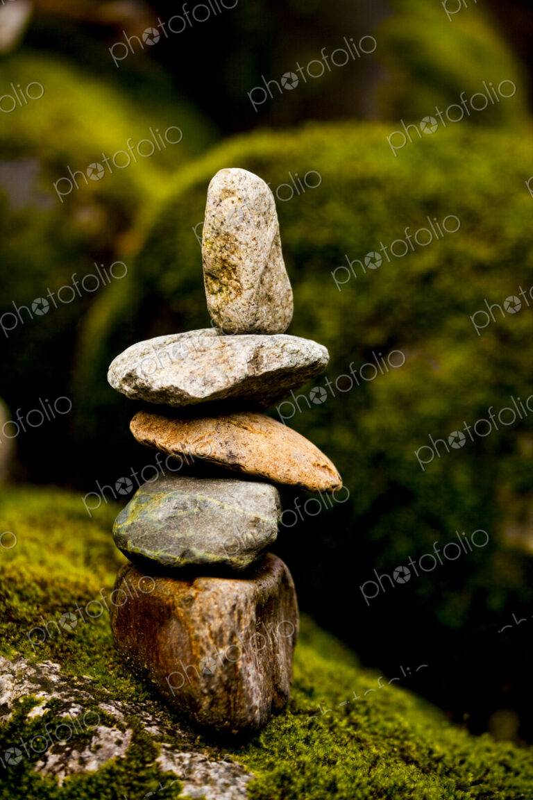 A stack of small rocks balanced on top of each other by a river.
