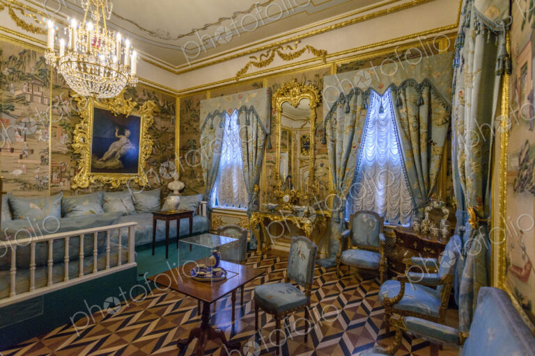 A state bedroom in the Peterhof palace with a bed and sofas, windows and painted wall…