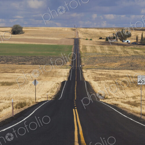 A straight rural road through crops fields, stretching into the distance at Palouse,…