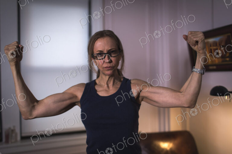 A strong woman with toned arms and clenched fists.