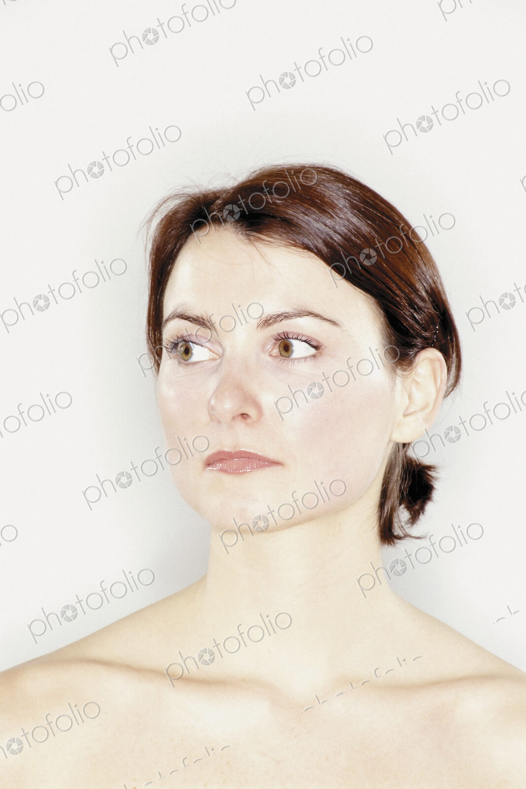 A studio portrait of a woman with brown hair tied back off her face.