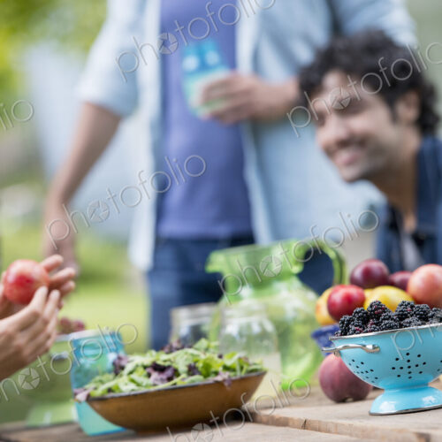 A summer party outdoors. A group of friends at a table.