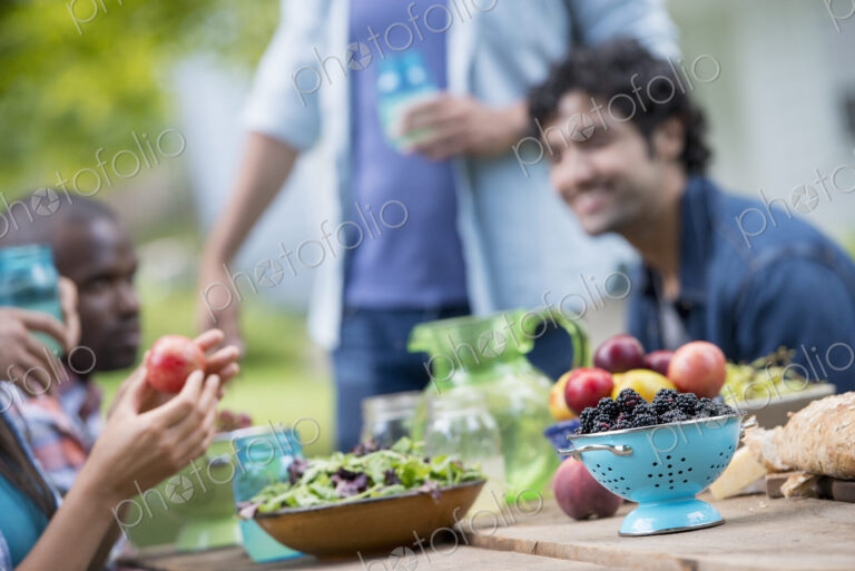 A summer party outdoors. A group of friends at a table.
