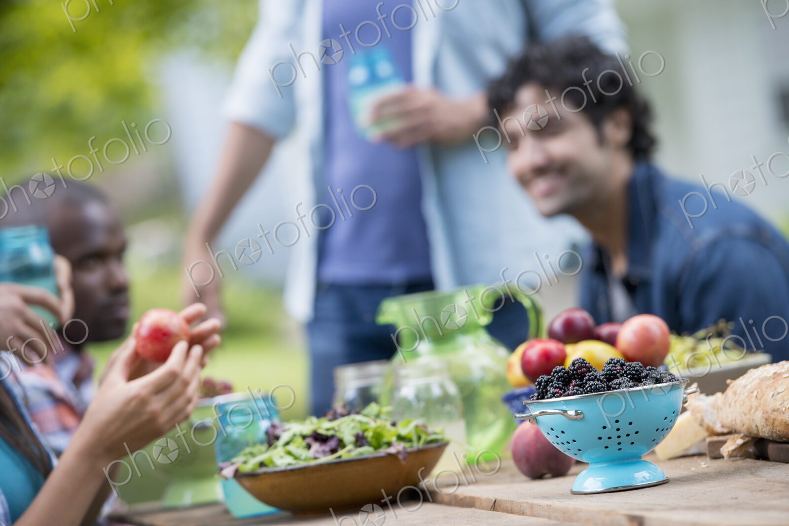 A summer party outdoors. A group of friends at a table.