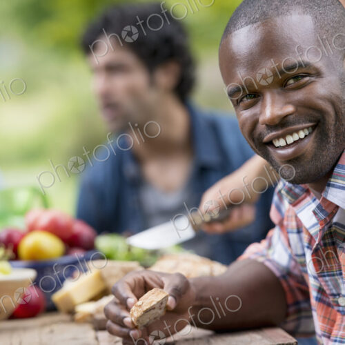 A summer party outdoors. A man smiling at the camera.