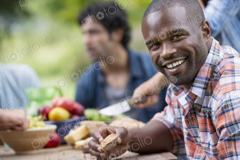A summer party outdoors. A man smiling at the camera.