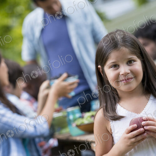 A summer party outdoors. Adults and children around a table. A summer party outdoors. Adults and children around a table.