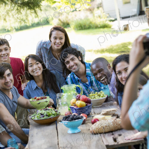 A summer party outdoors. Adults and children posing for a photograph.