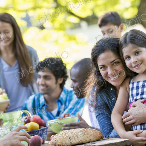 A summer party outdoors. Adults and children smiling and looking at the camera.