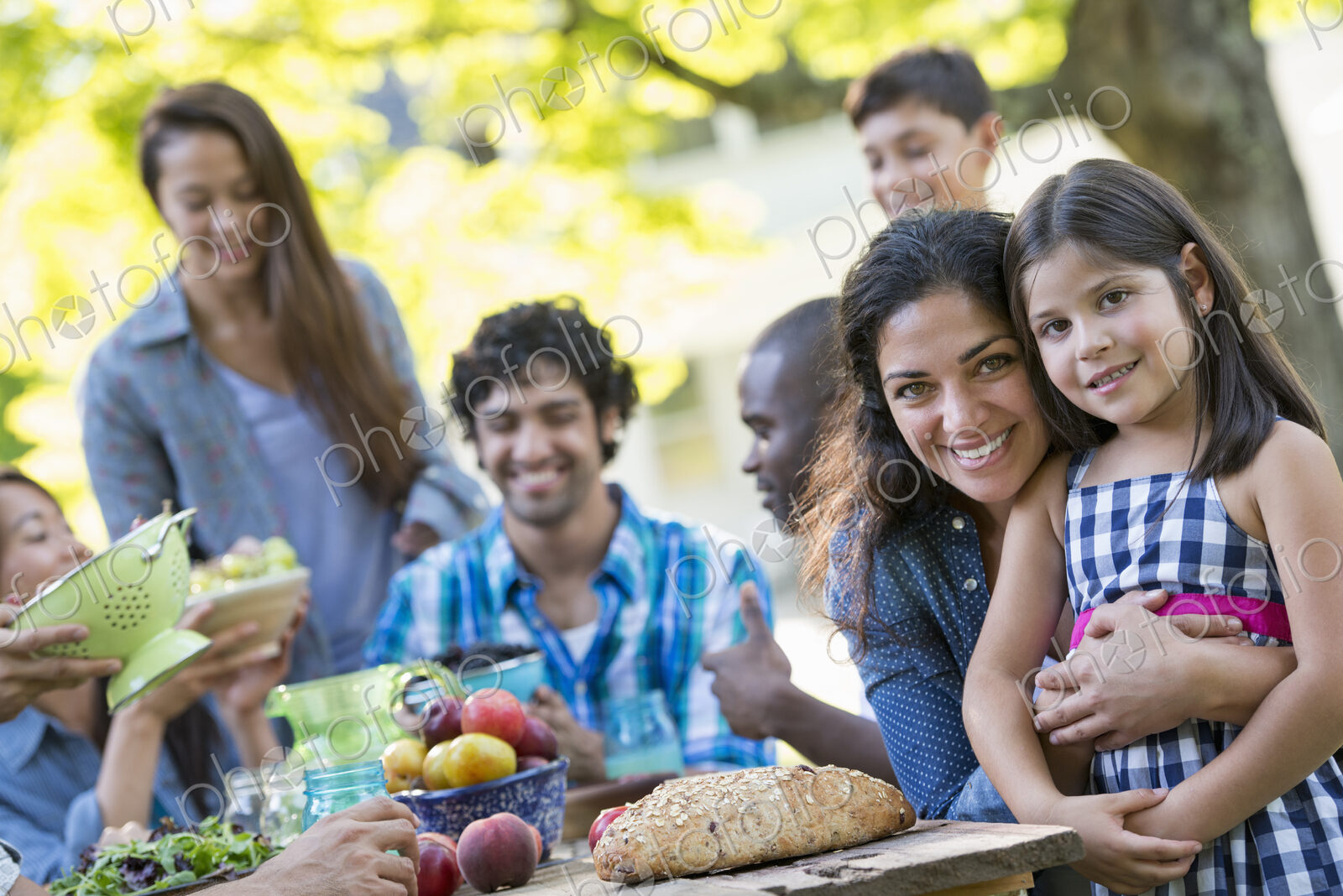 A summer party outdoors. Adults and children smiling and looking at the camera.