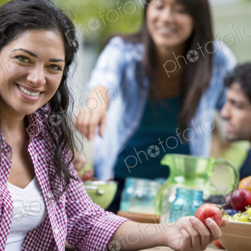 A summer party outdoors. Four friends at a table.