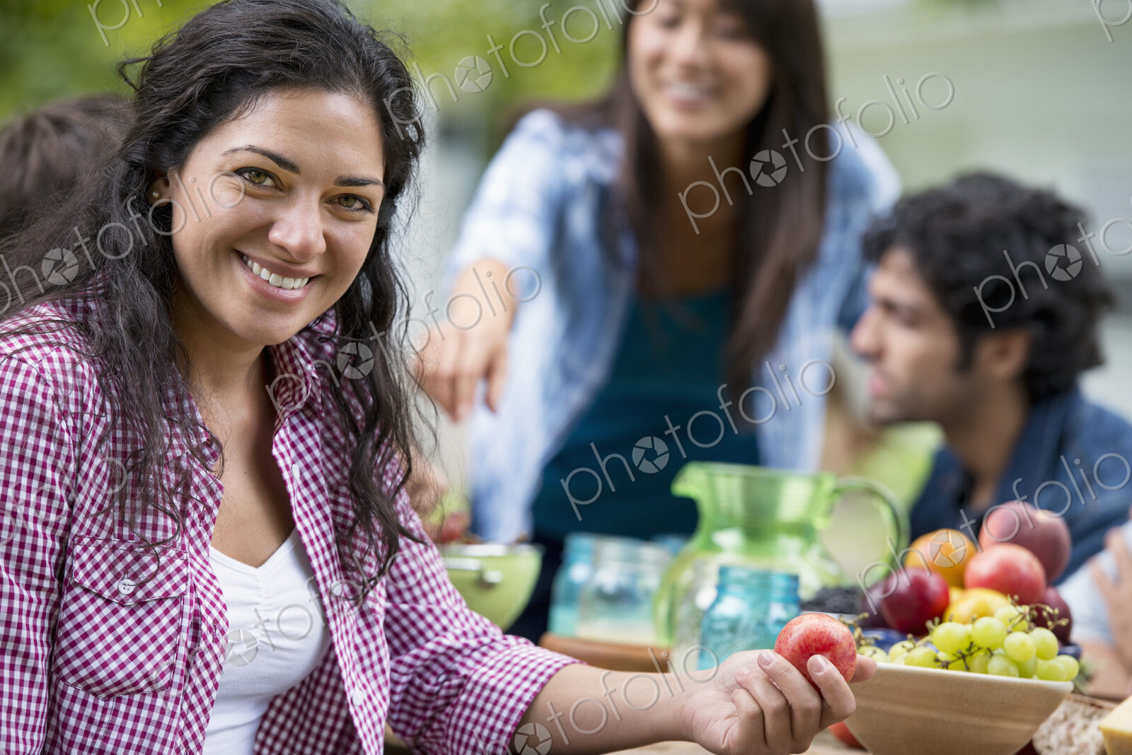 A summer party outdoors. Four friends at a table.