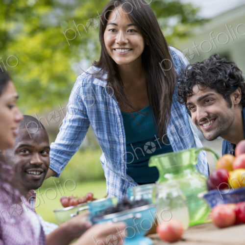 A summer party outdoors. Four people at a table.