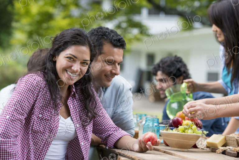 A summer party outdoors. Friends around a table.
