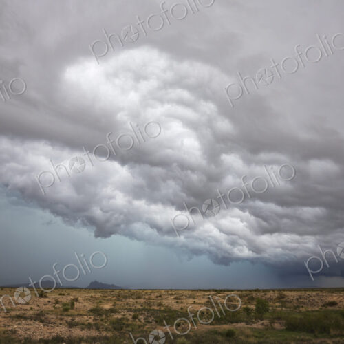 A supercell storm, cloud formations just above the horizon, white clouds and grey layers. A supercell storm, cloud formations just above the horizon, white clouds and grey layers.
