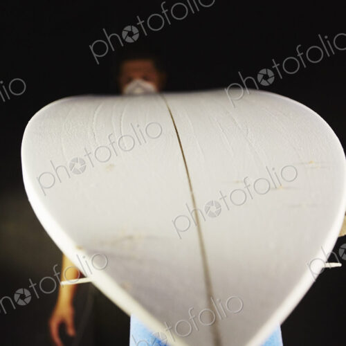 A surfboard in a workshop waiting for repair.