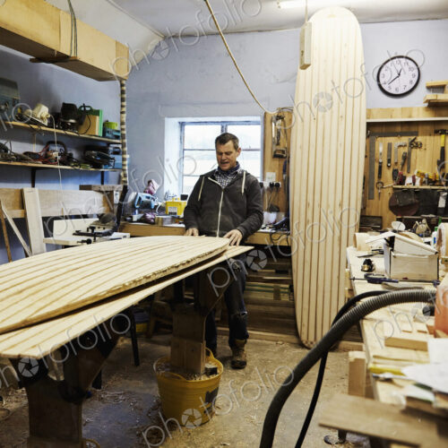 A surfboard workshop, a long board leant upright and a board in production on a… A surfboard workshop, a long board leant upright and a board in production on a…