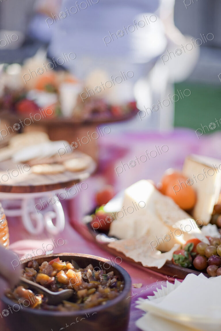 A table laid with a buffet selection of food dishes. Desserts and cheese board.